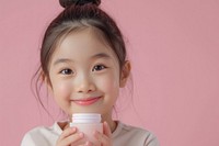 Little south east asian girls holding cosmetic product portrait child photo.