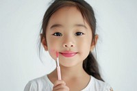 Little south east asian girl cosmetics portrait holding.