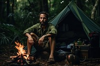 Brazilian man camping outdoors sitting.
