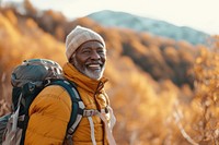 African middle age man hiking mountain backpack autumn.