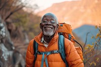 African senior man hiking backpacking mountain smile.