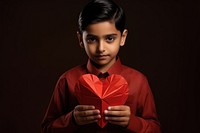 Indian kid holding red heart child celebration surprise.