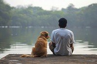 Indian man sitting with dog on jetty outdoors animal mammal.