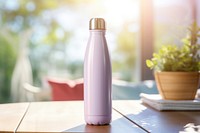 Women touching pastel color metal water bottle on the table drink refreshment drinkware.