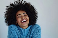 South african woman with a wig and curly hair sweater laughing smile.