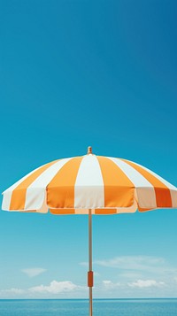Orange and white striped umbrella against a blue sky vacation yellow architecture. AI generated Image by rawpixel.