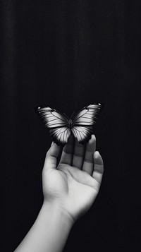 A hand with a butterfly photography finger black.
