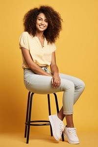 Smiling woman sitting on stool hair individuality curly hair.
