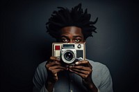 African student holding polaroid camera portrait photo photographing.
