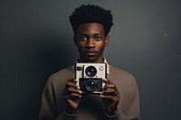 African student holding polaroid camera portrait adult photo.