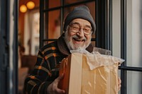 Happy mature man with open parcel at home adult box architecture.