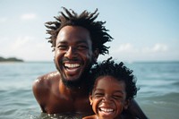 Black father and a son beach photography laughing.