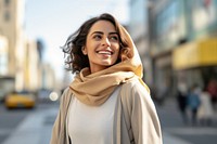 A happy Middle east woman in casual attire walk along a crosswalk looking street smile.