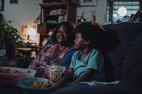 Daily life of black mom and daughter wacthing TV in the room family adult happy.