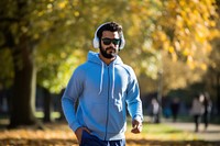 Pakistani man jogging headphones sweatshirt.