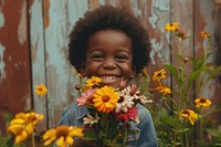 Black British American kid flower portrait outdoors.