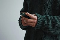 Mobile phone sweater holding adult.