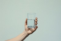 Hand holding water glass refreshment transparent drinkware.