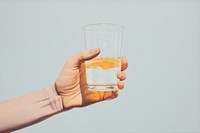 Hand holding orange juice glass drink refreshment transparent.