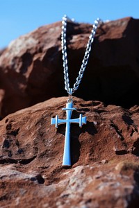 A sterling silver cross necklace outdoors pendant symbol.