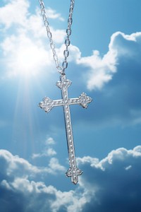 A sterling silver cross necklace outdoors symbol sky.