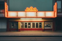 Old movie theater marquee in the 1970s city architecture illuminated.