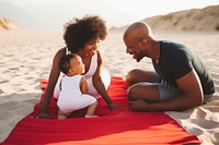 Black family on a beach mat with a baby in towel photography portrait adult.