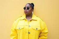 Cool chubby young black woman with fashionable clothing style full body on colored background jewelry individuality accessories.