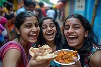 Indian girls eating food laughing smiling.