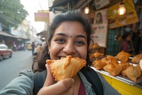 Indian blogger eating food smiling bread.