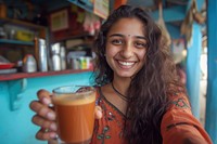 Indian girl making smiling selfie drink.