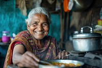Indian grandfather cooking food smiling adult.