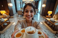 Indian hotel waitress serving smiling coffee smile.