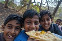 Indian boys eating food portrait outdoors.