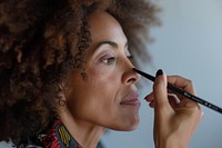 Middle aged multiracial woman doing her makeup fashion adult hairstyle.