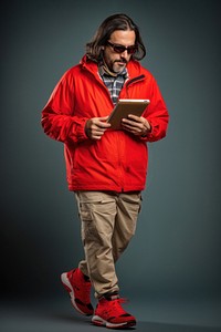 Person withperson reading newspaper walking headphones footwear portability electronics sunglasses.