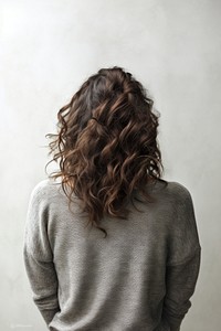 A woman in jeans looking up on a white background isolation back view adult contemplation hairstyle.
