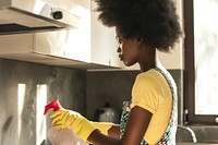 African American young woman cleaning kitchen adult.
