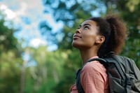 Mixed race woman with backpack outdoors looking nature.