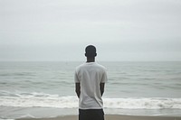 African American young man standing beach outdoors.