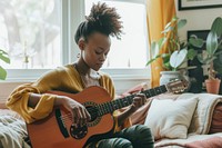Black South African woman guitar musician playing guitar.