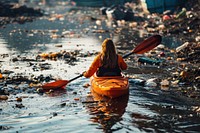 Woman kayaking in dirty polluted river pollution water boat. 