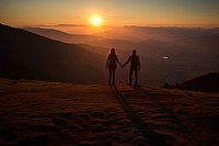 Tourists holding hand on the hill in the sunrise holding hands togetherness tranquility.