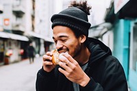 Young handsome Hong Kong man enjoying local street food biting adult architecture. AI generated Image by rawpixel.