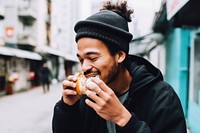 Young handsome Hong Kong man enjoying local street food biting adult architecture. 