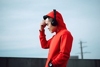 East Asian man using smartphone with headphones on rooftop adult photo architecture. 