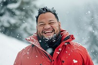 Samoan man outdoors snow laughing.