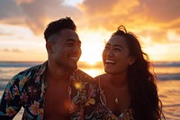 Samoan couple laughing outdoors sunset.
