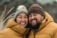 Samoan couple laughing outdoors winter.