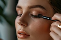 Woman close eyes with a brush using makeup cosmetics perfection hairstyle. AI generated Image by rawpixel.